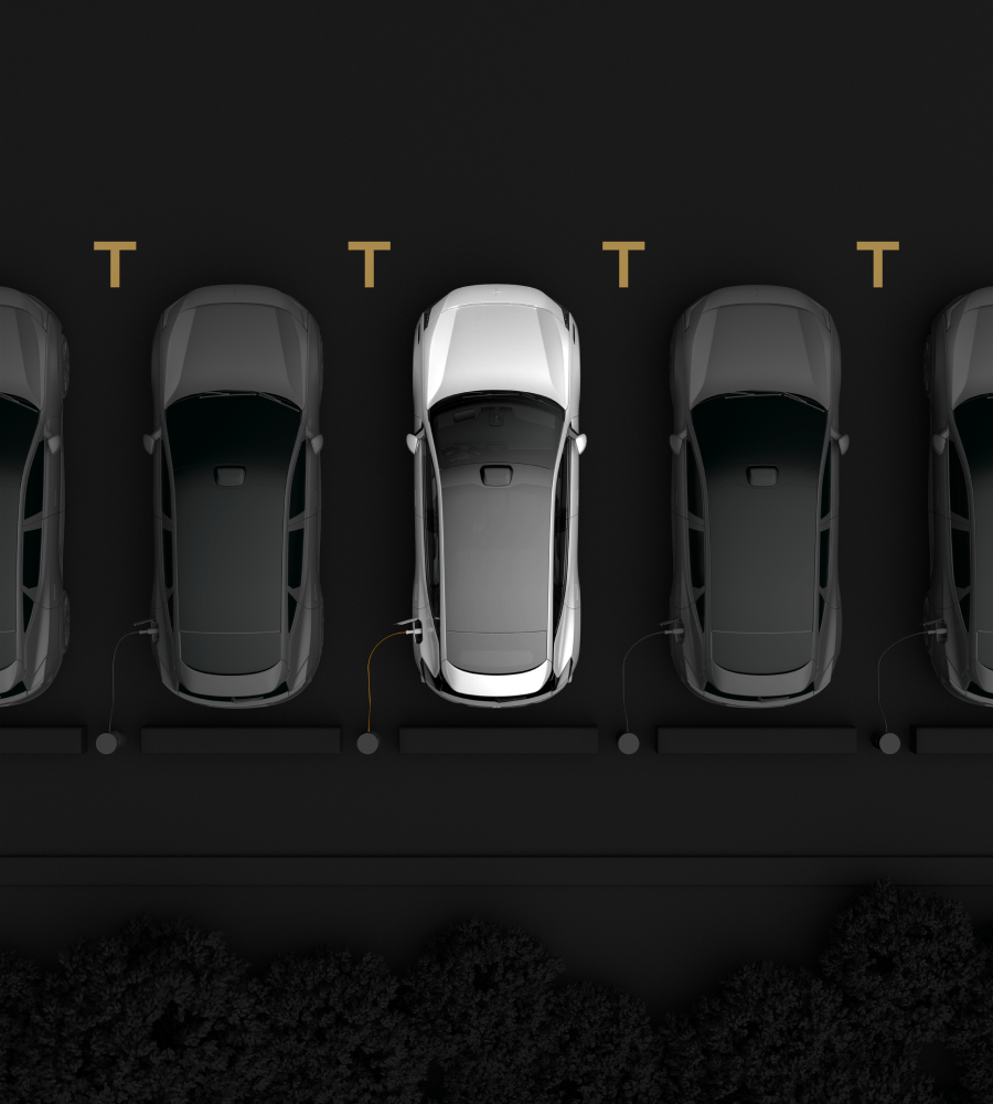 Cars parked in line seen from above. One white car in the middle and black cars on both sides of it.