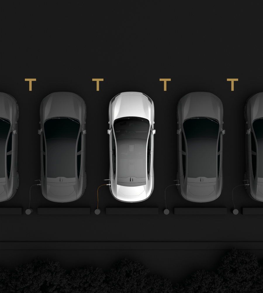 Cars parked in line seen from above. One white car in the middle and black cars on both sides of it.